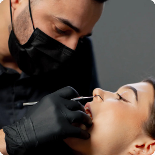 Dentist treating a patient with gloves and a mask
